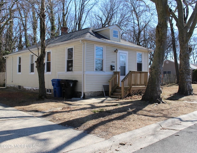 view of front of home with a shingled roof and a chimney