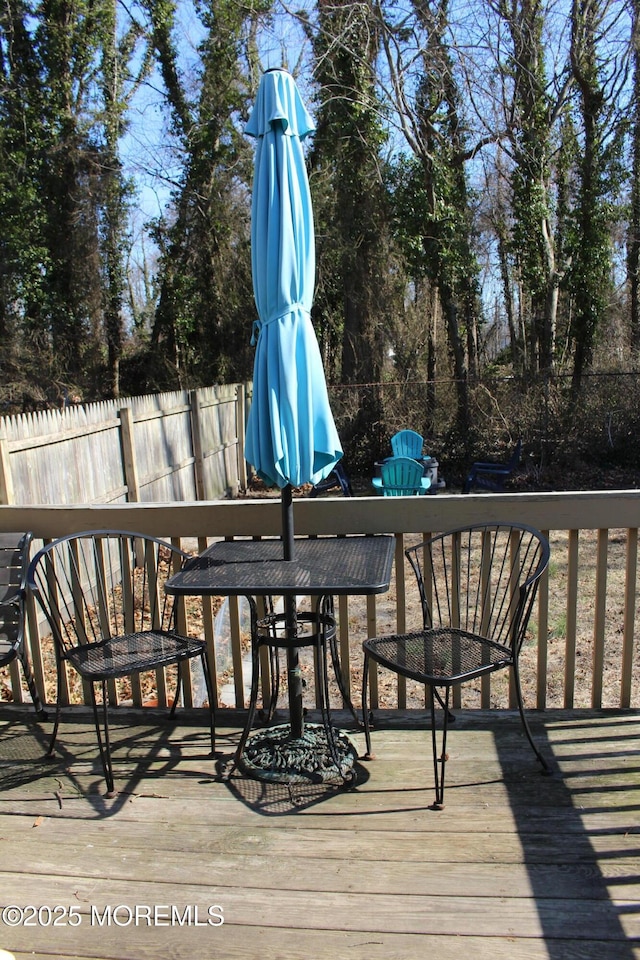 wooden deck with outdoor dining area and fence