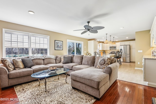 living area with recessed lighting, ceiling fan, baseboards, and light wood-style floors