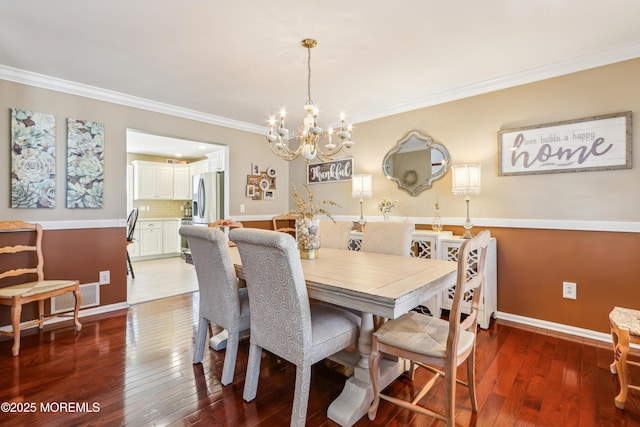 dining area with visible vents, crown molding, baseboards, and hardwood / wood-style floors