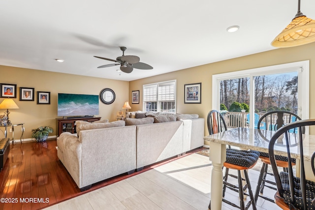 living area featuring recessed lighting, wood finished floors, baseboards, and ceiling fan