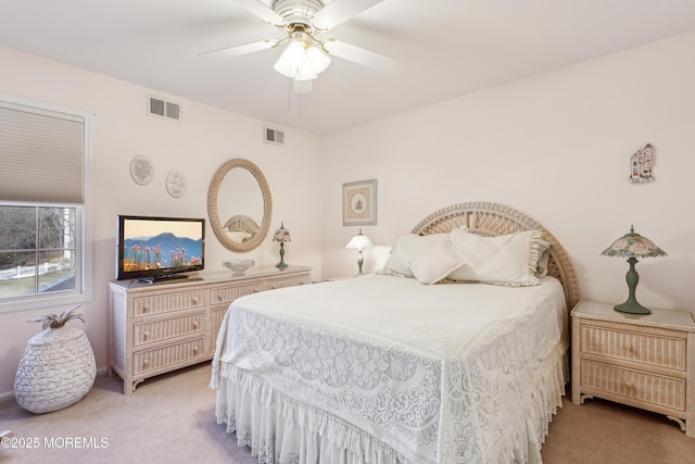 bedroom featuring visible vents, light carpet, and a ceiling fan