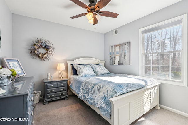 carpeted bedroom featuring baseboards, visible vents, and ceiling fan