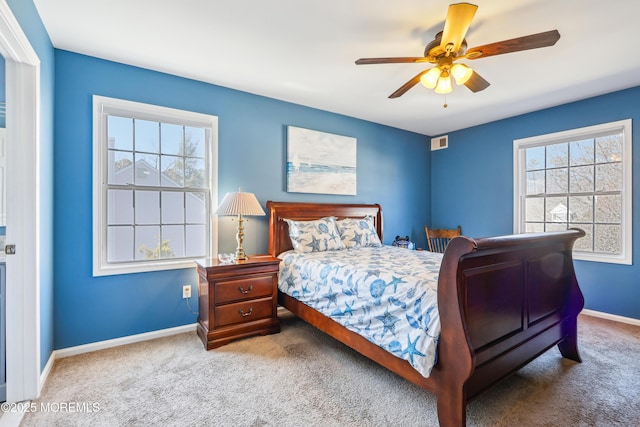 carpeted bedroom with visible vents, a ceiling fan, and baseboards