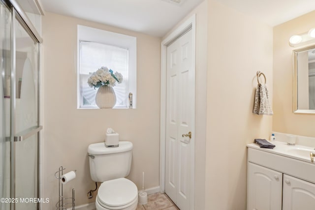 full bathroom featuring a shower with door, baseboards, toilet, tile patterned floors, and vanity