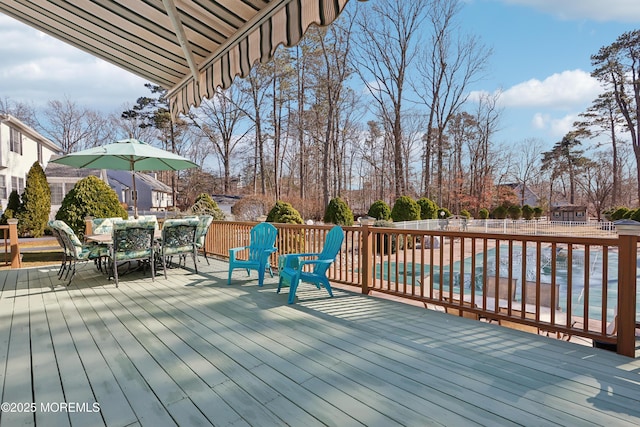 wooden deck with a fenced in pool, outdoor dining area, and fence