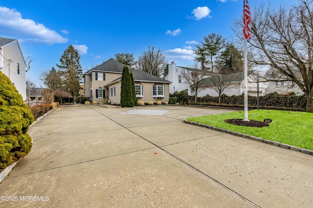 traditional-style home featuring driveway and a front yard