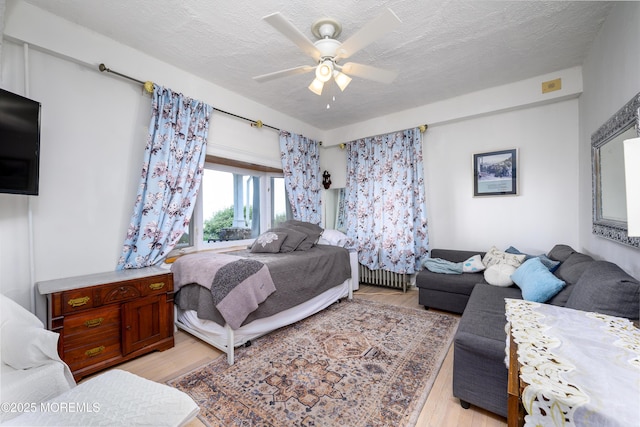 75 Highland Ave, Highlands, NJ 07732 - bedroom featuring radiator heating unit, a textured ceiling, light wood-type flooring, and a ceiling fan