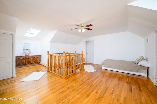 75 Highland Ave, Highlands, NJ 07732 - bedroom with a baseboard heating unit, vaulted ceiling with skylight, light wood-style floors, and visible vents