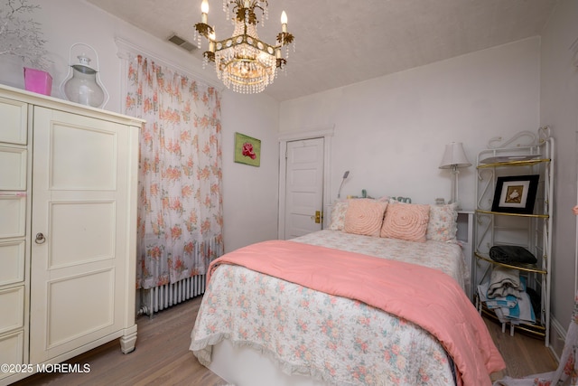 75 Highland Ave, Highlands, NJ 07732 - bedroom featuring visible vents, an inviting chandelier, and wood finished floors