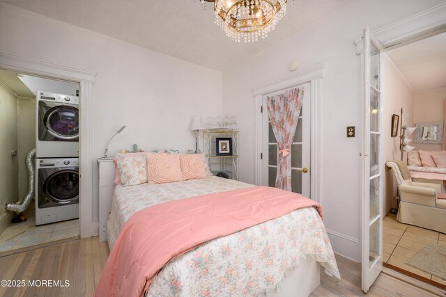 75 Highland Ave, Highlands, NJ 07732 - bedroom with a notable chandelier, stacked washer and clothes dryer, and wood finished floors