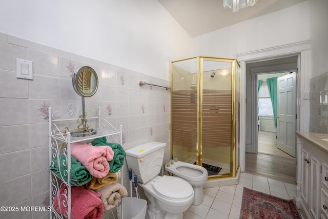 75 Highland Ave, Highlands, NJ 07732 - bathroom with toilet, a stall shower, a bidet, tile walls, and tile patterned flooring