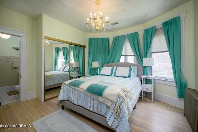 75 Highland Ave, Highlands, NJ 07732 - bedroom featuring radiator, a textured ceiling, an inviting chandelier, and wood finished floors