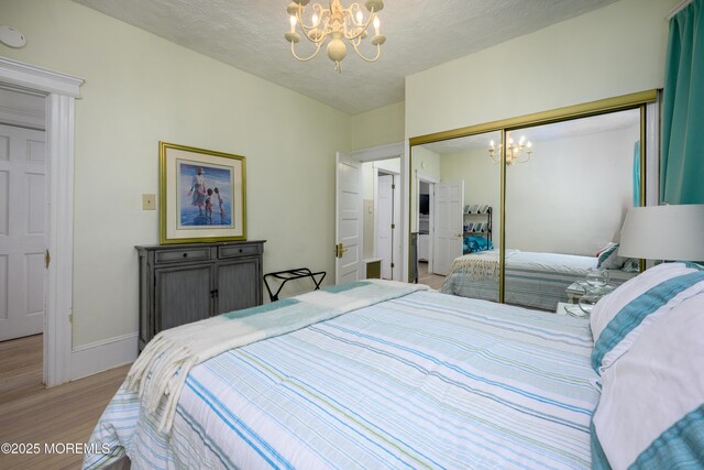 75 Highland Ave, Highlands, NJ 07732 - bedroom featuring a closet, a notable chandelier, light wood-type flooring, and baseboards