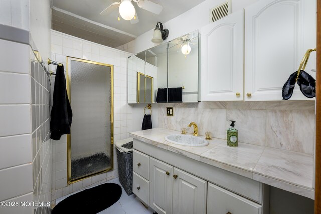 75 Highland Ave, Highlands, NJ 07732 - bathroom featuring vanity, visible vents, a stall shower, ceiling fan, and tile walls