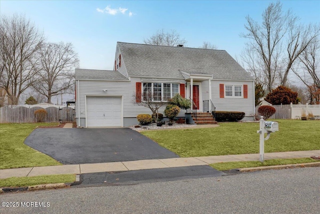 cape cod home featuring aphalt driveway, an attached garage, a shingled roof, fence, and a front yard