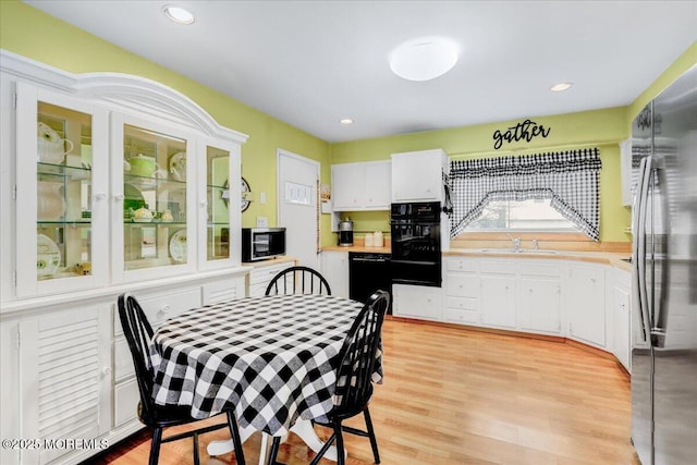 dining area with light wood finished floors and recessed lighting