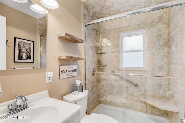 bathroom featuring vanity, a shower stall, and toilet