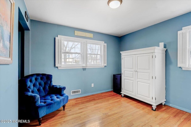 sitting room featuring light wood-style floors, baseboards, and visible vents