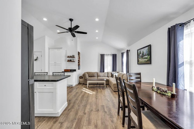 dining area with light wood finished floors, recessed lighting, a ceiling fan, and vaulted ceiling