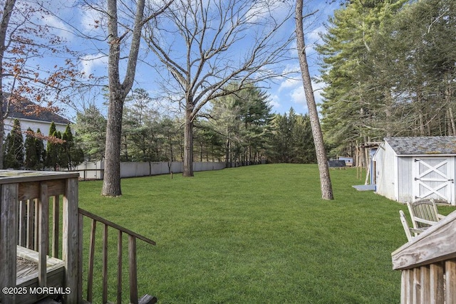 view of yard with fence, an outbuilding, and a shed