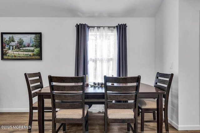 dining area with baseboards and wood finished floors