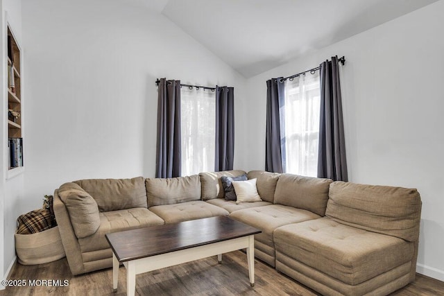 living room with baseboards, lofted ceiling, and wood finished floors