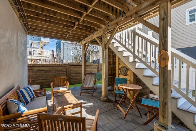 view of patio / terrace with outdoor lounge area, stairs, and fence