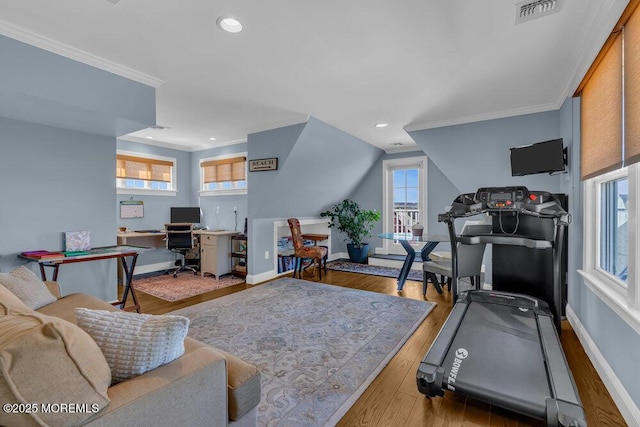 workout area with visible vents, crown molding, baseboards, and wood finished floors