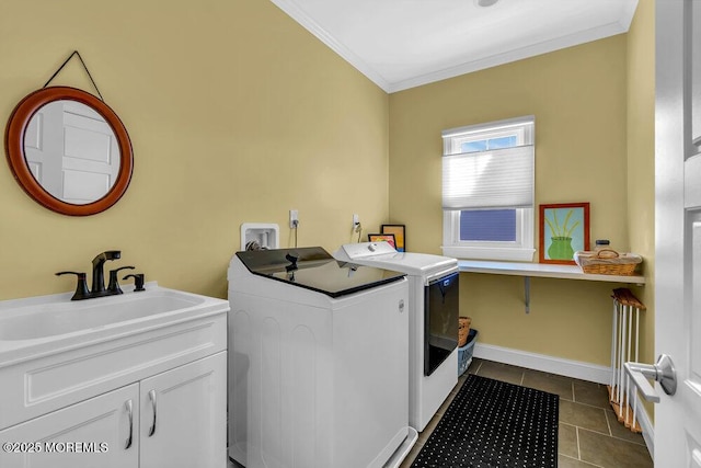 laundry area with cabinet space, a sink, washer and dryer, crown molding, and dark tile patterned floors