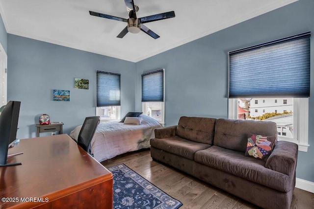 bedroom with ornamental molding, baseboards, ceiling fan, and wood finished floors