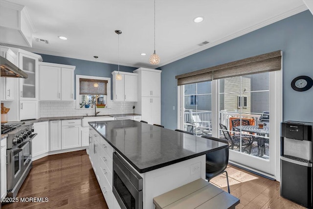 kitchen with a sink, stainless steel appliances, and ornamental molding