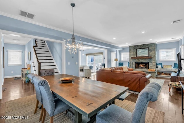 dining area with visible vents, crown molding, and hardwood / wood-style flooring