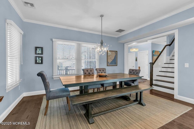 dining room with visible vents, crown molding, an inviting chandelier, and wood finished floors