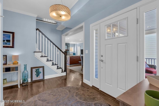 foyer with stairway, crown molding, baseboards, and wood finished floors