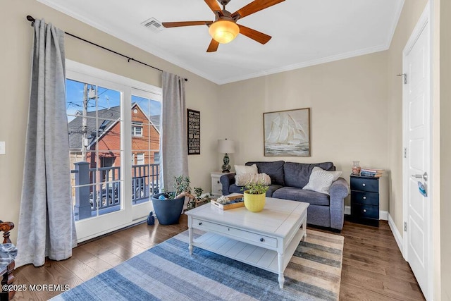 living room featuring a ceiling fan, crown molding, and wood finished floors