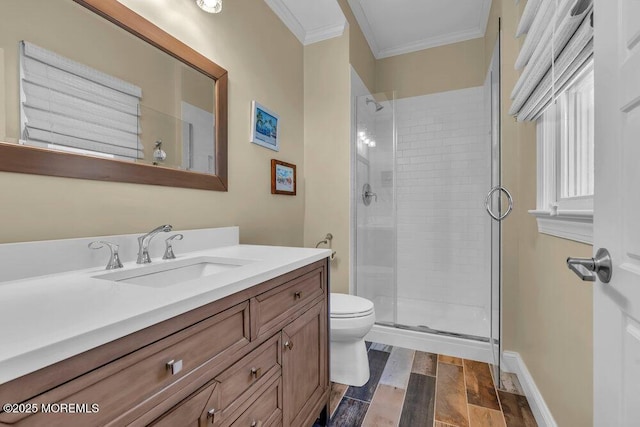 bathroom featuring a stall shower, toilet, crown molding, and vanity