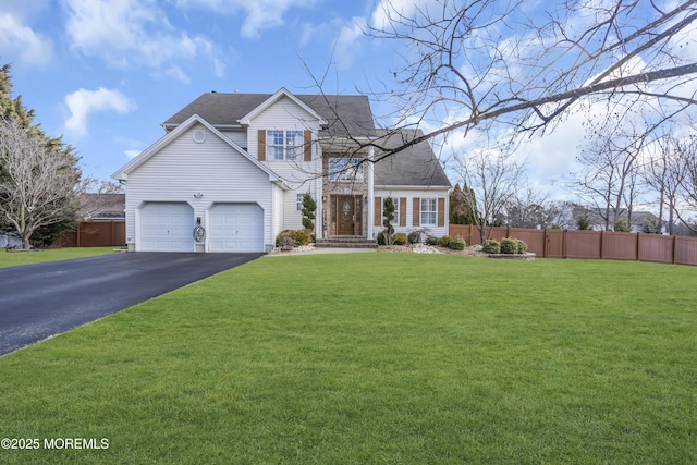 view of front of house featuring driveway, a garage, fence, and a front yard