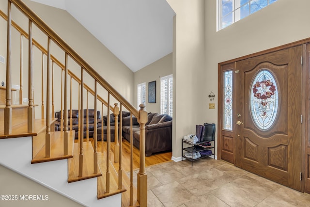 foyer with stairs and high vaulted ceiling