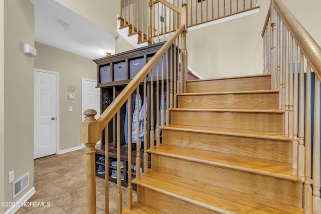 staircase featuring visible vents and baseboards