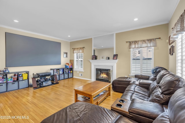 living room featuring plenty of natural light, wood finished floors, and a glass covered fireplace