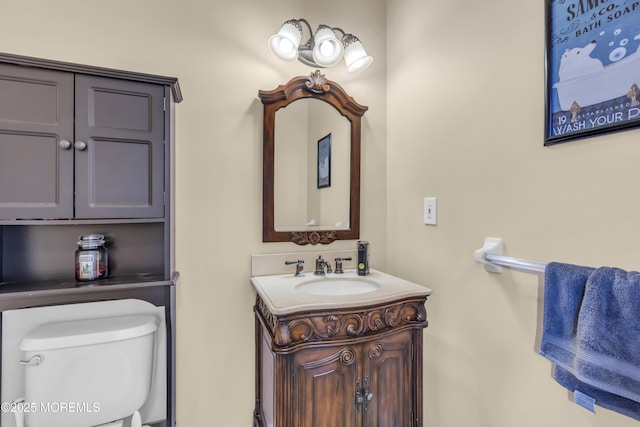 half bath featuring vanity and toilet