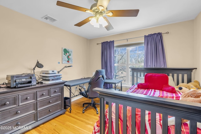 bedroom with ceiling fan, light wood-style flooring, and visible vents