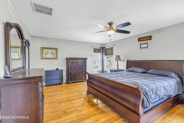 bedroom featuring a ceiling fan, visible vents, and light wood-style flooring