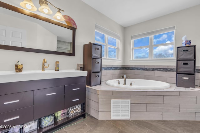 full bathroom with a bath, vanity, and visible vents