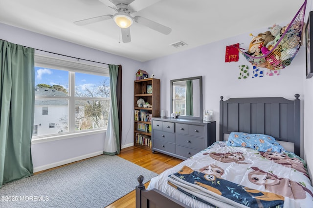 bedroom featuring light wood finished floors, multiple windows, visible vents, and baseboards