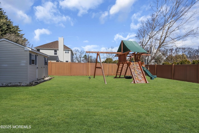 view of playground featuring a fenced backyard, an outdoor structure, and a yard