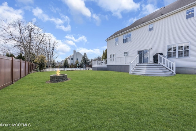 view of yard featuring an outdoor fire pit, a fenced backyard, and a wooden deck