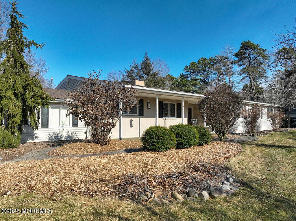 ranch-style house featuring a chimney and a front lawn