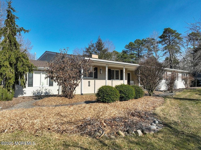 ranch-style house featuring a chimney and a front lawn